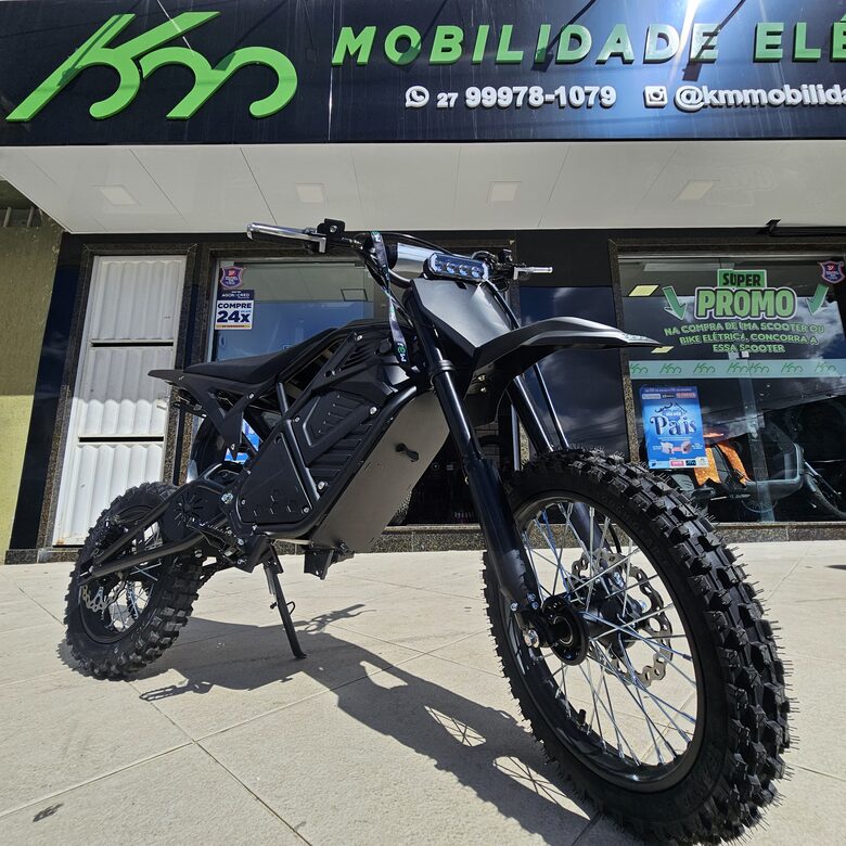 Moto elétrica off-road preta em frente à loja da KM